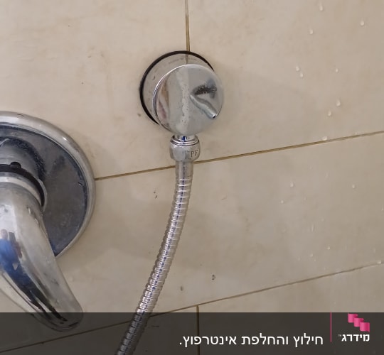 ברז מים עם צינור מתכת מחובר לקיר